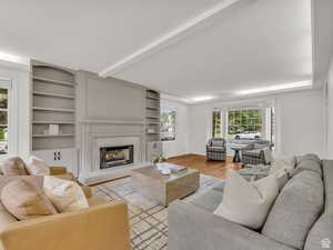 Living area featuring a high end fireplace, wood finished floors, and built in features