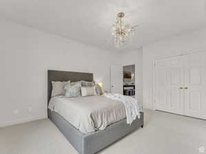Bedroom with carpet flooring, a chandelier, and a closet