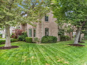 View of front of property with brick siding and a front yard