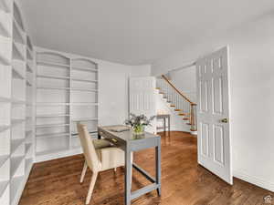 Office space with dark wood finished floors and built in features