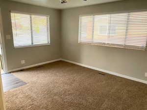 Carpeted spare room with baseboards and ceiling fan