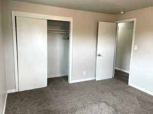 Unfurnished bedroom featuring a closet and carpet