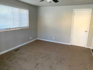 Spare room featuring carpet floors and a ceiling fan