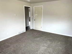Empty room featuring carpet and baseboards