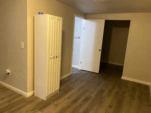 Unfurnished bedroom with dark wood finished floors and a closet