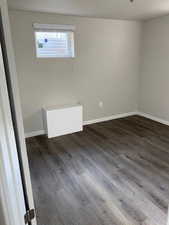 Empty room with dark wood-style floors and baseboards