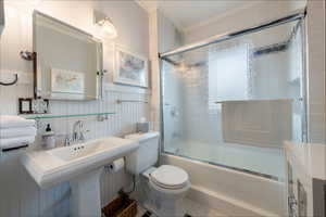 Bathroom with combined bath / shower with glass door and toilet