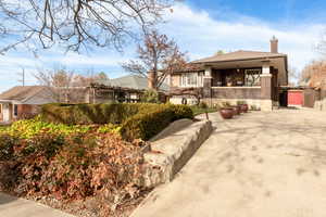 View of front facade featuring a chimney and brick siding