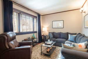 Living room with ornamental molding and wood finished floors