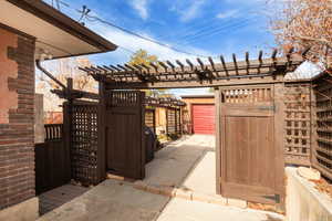 Gate featuring a pergola and a patio