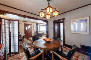 Dining room with wood finished floors and crown molding