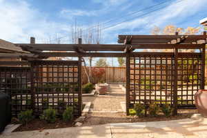 Fenced backyard with a pergola and a patio area