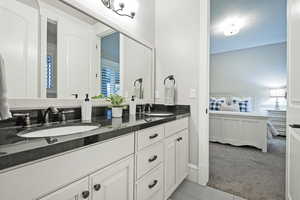 Full bath with double vanity, light colored carpet, connected bathroom, and light tile patterned floors