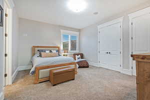 Carpeted bedroom with a closet and baseboards and daylight windows