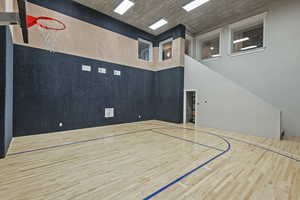Indoor basketball court featuring solid hardwood floors