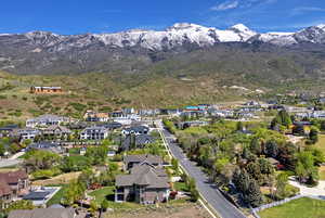 Aerial view of property and surrounding area with a mountain backdrop and nearby suburban area