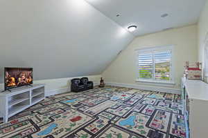 Playroom with vaulted ceiling and baseboards