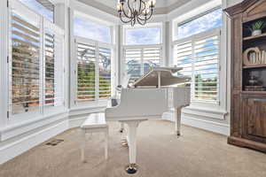 Sitting room with carpet flooring, crown molding, and a chandelier and amazing mountain views