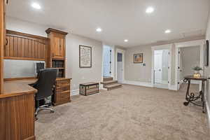 Loft for office space with recessed lighting, light carpet