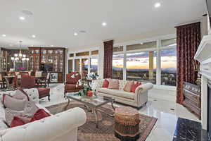 Living area featuring a chandelier, a premium fireplace, recessed lighting, wine cooler, and light tile patterned floors