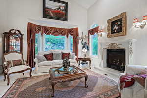Living room featuring high vaulted ceiling and a high end fireplace