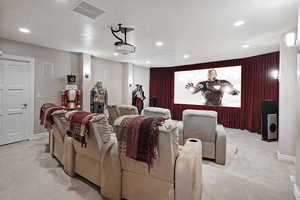 Home theater room with recessed lighting and light colored carpet