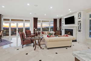 Living area with recessed lighting, a premium fireplace, and french doors