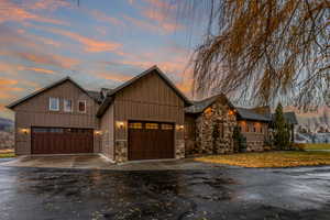 View of front of property with asphalt driveway, board and batten siding, and an attached garage