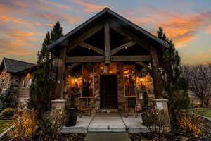 Doorway to property with stone siding and a porch