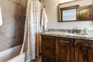 Bathroom featuring shower / tub combo with curtain and vanity
