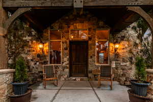 Property entrance with stone siding and a patio