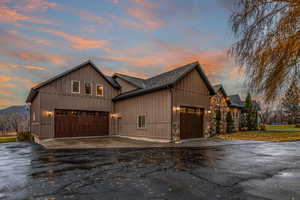 View of front facade with asphalt driveway and board and batten siding