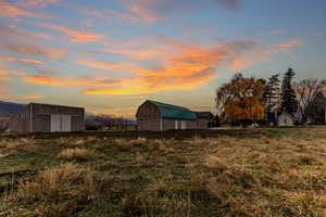 View of grassy yard with an outdoor structure and a barn