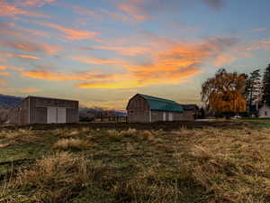 View of grassy yard with an outdoor structure and a barn