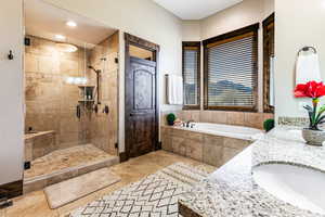 Bathroom featuring double vanity, a stall shower, a bath, and recessed lighting