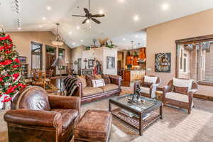 Carpeted living room featuring rail lighting, a ceiling fan, high vaulted ceiling, and recessed lighting