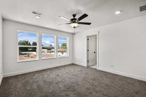 Carpeted spare room with a ceiling fan and a textured ceiling