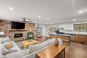 Living area with light wood finished floors, a fireplace, and recessed lighting