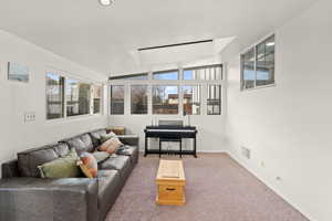 Carpeted living room featuring lofted ceiling and healthy amount of natural light