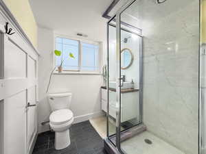 Full bathroom featuring vanity and a marble finish shower