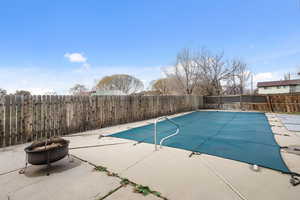 View of swimming pool featuring a fenced backyard, a patio area, and a fire pit