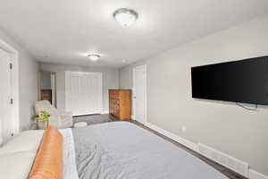 Bedroom featuring a closet, a textured ceiling, and wood finished floors