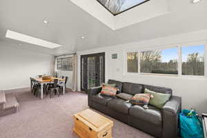 Carpeted living area featuring a skylight and recessed lighting