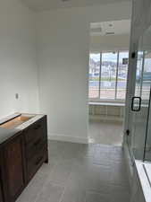 Bathroom featuring a stall shower, vanity, and light tile patterned floors