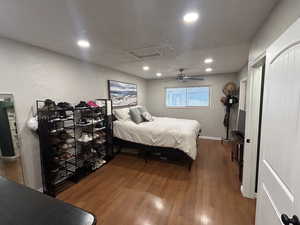 Bedroom featuring attic access, wood finished floors, ceiling fan, a textured ceiling, and recessed lighting