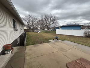 Fenced backyard featuring a patio and a playground