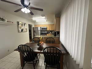 Dining area featuring light tile patterned flooring and a ceiling fan