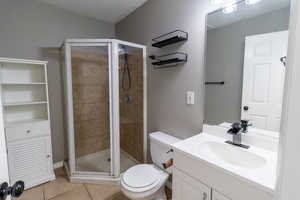 Full bathroom featuring light tile patterned flooring, vanity, and a stall shower