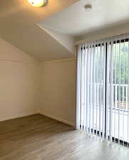 Additional living space with a textured ceiling, lofted ceiling, and wood finished floors