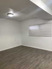 Spare room featuring a textured ceiling and dark wood-style flooring